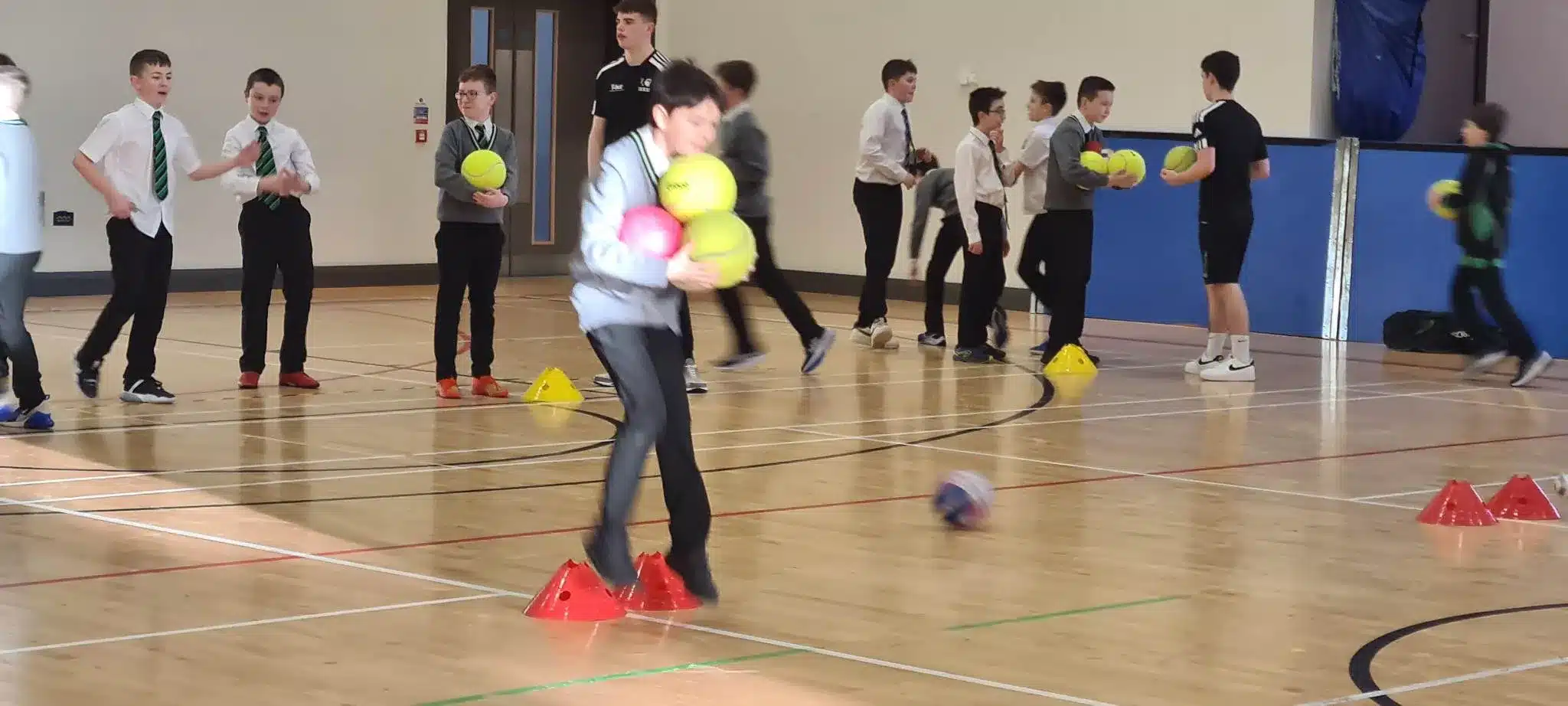 Children taking part in a team ball challenge during a school PE session.