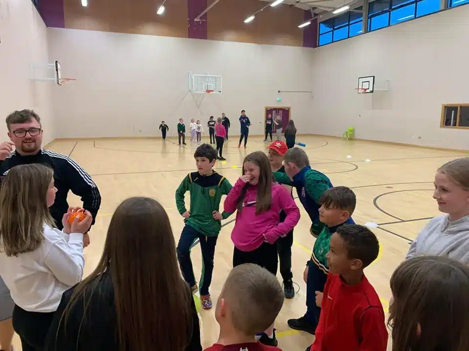Children taking part in a group activity during an indoor sports session.
