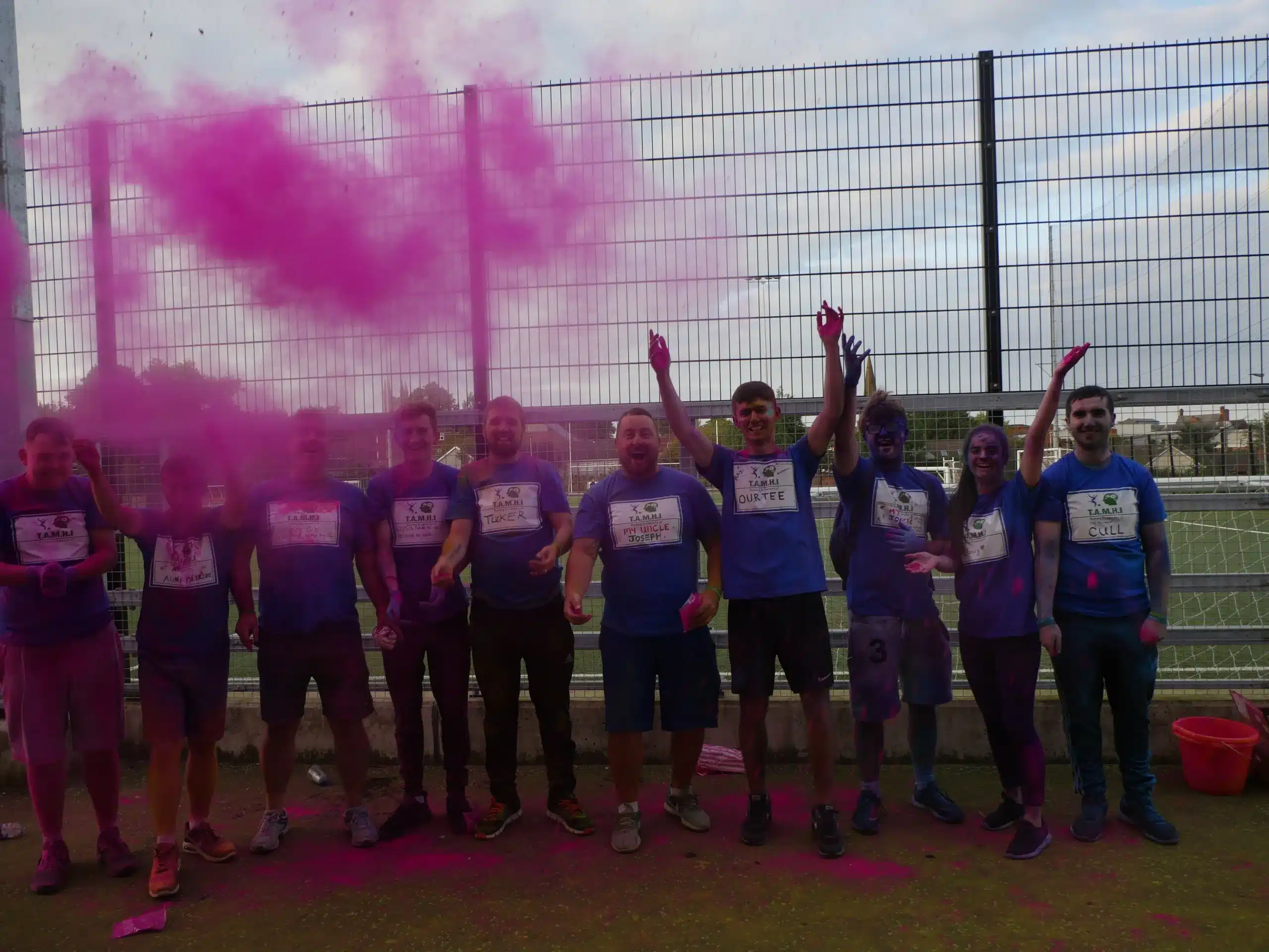 Participants celebrating during a colourful charity fun run event.